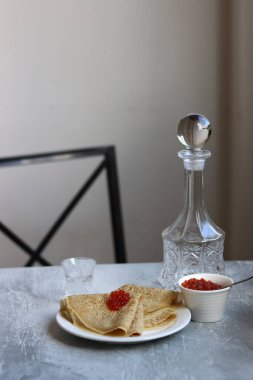 Tabaktaki küçük krepler. Somon havyarlı krep. Baharatlı yiyecekler, yakın plan fotoğraf. Geleneksel Fransız krepleri. 