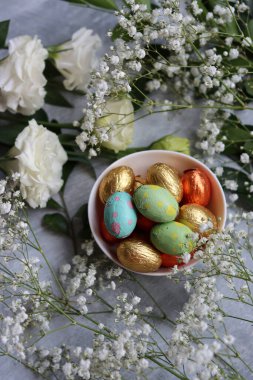 Paskalya tatlılarının canlı renkleri. Beyaz çingene çiçekleri ve çikolatalı yumurtalarla dolu renkli bir hayat.. 