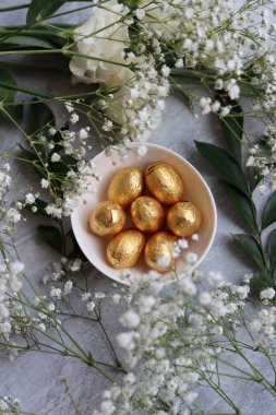 Paskalya tatlılarının canlı renkleri. Beyaz çingene çiçekleri ve çikolatalı yumurtalarla dolu renkli bir hayat.. 