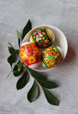 Masadaki paskalya yumurtaları. Yumurtalar ve beyaz çiçeklerle dolu bir hayat. Paskalya kutlaması kavramı. 