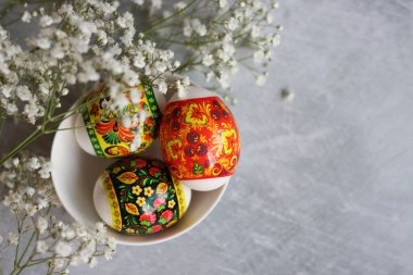 Masadaki paskalya yumurtaları. Yumurtalar ve beyaz çiçeklerle dolu bir hayat. Paskalya kutlaması kavramı. 