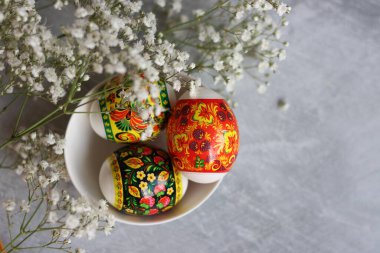 Masadaki paskalya yumurtaları. Yumurtalar ve beyaz çiçeklerle dolu bir hayat. Paskalya kutlaması kavramı. 