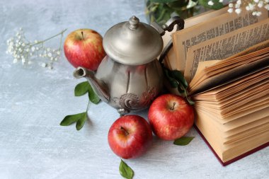 Basit kompozisyon açık kitap, beyaz çiçekler ve kırmızı elmalarla hayat devam ediyor. Eğitim kavramı. 