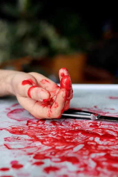 Hand Knife on bloody messy background with copy space. Suicide Homicide Abuse Domestic killing concept. Bloody hand holding a knife with blood.