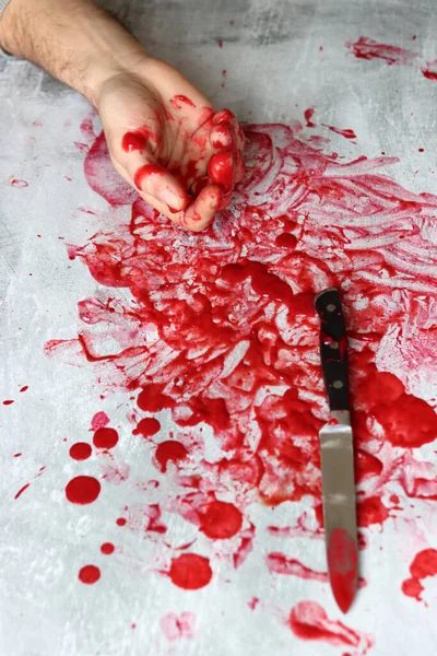 Hand Knife on bloody messy background with copy space. Suicide Homicide Abuse Domestic killing concept. Bloody hand holding a knife with blood.