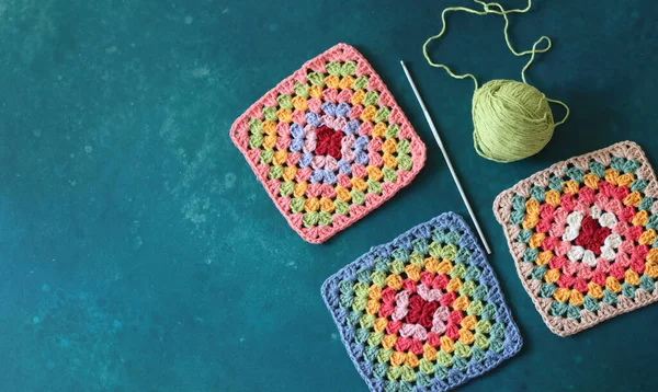 Crochet project in making. Colorful crochet squares close up photo. Hand made top in process.