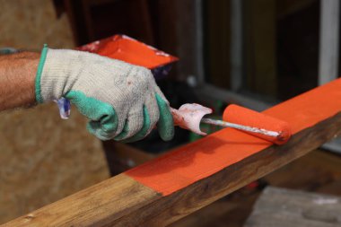 İşçi, odunu nem geçirmekten korumak için ahşap koruyucu sürüyor. Ev yenileme konsepti. 