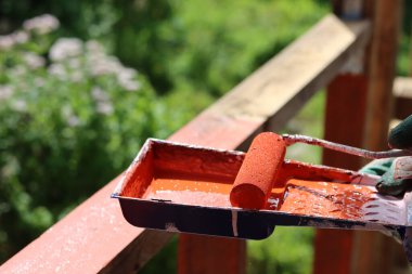 İşçi, odunu nem geçirmekten korumak için ahşap koruyucu sürüyor. Ev yenileme konsepti. 