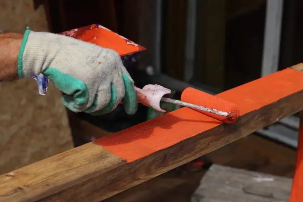 Pracownik Malujący Drewnianą Deskę Czerwoną Farbą Warsztacie — Zdjęcie stockowe