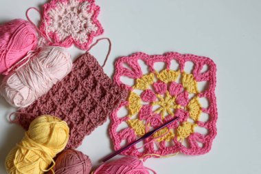 Beyaz arkaplanda farklı örülmüş elementler ve kopyalama alanı. El yapımı ev dekorasyonu. Güzel pembe ve sarı pamuk yumakları. Sanat ve zanaat konsepti. 