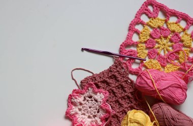 Beyaz arkaplanda farklı örülmüş elementler ve kopyalama alanı. El yapımı ev dekorasyonu. Güzel pembe ve sarı pamuk yumakları. Sanat ve zanaat konsepti. 