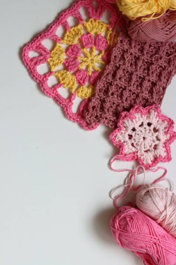 Beyaz arkaplanda farklı örülmüş elementler ve kopyalama alanı. El yapımı ev dekorasyonu. Güzel pembe ve sarı pamuk yumakları. Sanat ve zanaat konsepti. 