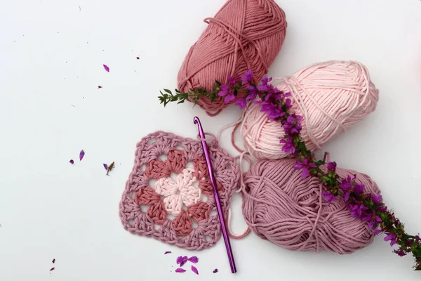 ピンクは 異なるピンク色の色合いの柔らかい綿糸ボールのおばあちゃんの正方形を編みました コピースペース付きの白い背景 スプリングクロチェットコンセプト — ストック写真
