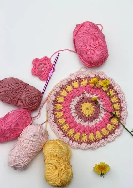 コピースペースで白い背景にピンクと黄色のマンダラを編みました 綿ヤーンボール クロチェットホック 花のトップビュー写真 手作りの装飾的な要素 — ストック写真