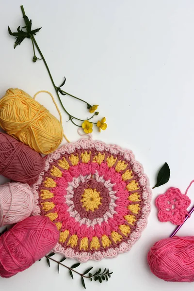 コピースペースで白い背景にピンクと黄色のマンダラを編みました 綿ヤーンボール クロチェットホック 花のトップビュー写真 手作りの装飾的な要素 — ストック写真