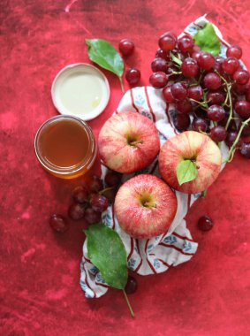 Üzüm ve elmalarla dokulu kırmızı arka planda hayat dolu metin için yer var. Sağlıklı yeme kavramı. 