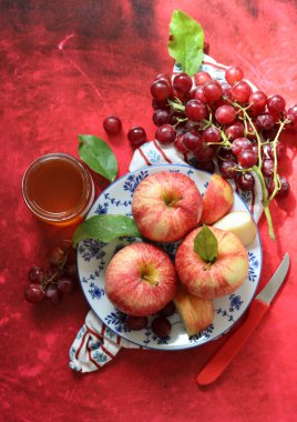 Üzüm ve elmalarla dokulu kırmızı arka planda hayat dolu metin için yer var. Sağlıklı yeme kavramı. 