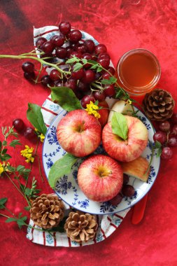 Üzüm ve elmalarla dokulu kırmızı arka planda hayat dolu metin için yer var. Sağlıklı yeme kavramı. 