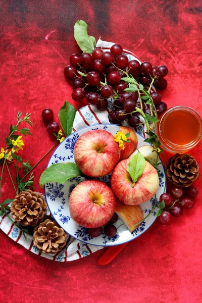 Rote Äpfel Und Trauben Auf Rotem Hintergrund Mit Einer Tasse — Stockfoto