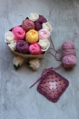 Yumuşak organik pamuktan yapılmış büyükanne kare deseni. Fotokopi alanı olan gri arkaplan. Bahar tığ işi fikirleri. 