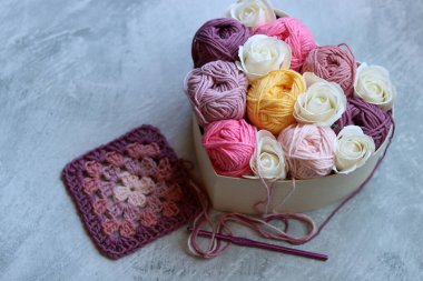 Tahta bir kutuda pamuk yumağından yapılmış bir buket. Yumuşak pembe organik ipliğin renkli fotoğrafı. Hobiler ve eğlence konsepti. Kopyalama alanı olan açık gri arkaplan. 