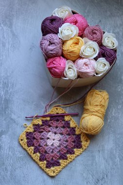 Tahta bir kutuda pamuk yumağından yapılmış bir buket. Yumuşak pembe organik ipliğin renkli fotoğrafı. Hobiler ve eğlence konsepti. Kopyalama alanı olan açık gri arkaplan. 