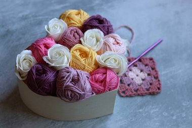 Tahta bir kutuda pamuk yumağından yapılmış bir buket. Yumuşak pembe organik ipliğin renkli fotoğrafı. Hobiler ve eğlence konsepti. Kopyalama alanı olan açık gri arkaplan. 