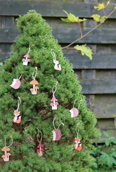 绿色冷杉树上的木制圣诞装饰 一张环保手工制作的圣诞装饰品的近照 — 图库照片