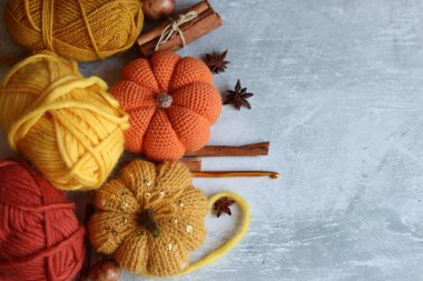 Gri arka planda örgü aksesuarları olan düz bir kompozisyon. Cadılar Bayramı için el yapımı süslemeler. Metin için boşluk.