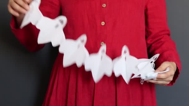 ハロウィーンの準備 コピースペースで黒い背景にお祝いのガーランドを保持する赤いドレスの若い女性 伝統的な秋の装飾は写真を閉じます ハッピーハロウィーンコンセプト — ストック動画