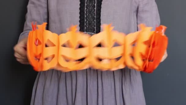 穿着衣服的女人拿着手工制作的节日花环 环保万圣节装饰用纸做的 秋季室内装潢的想法 — 图库视频影像