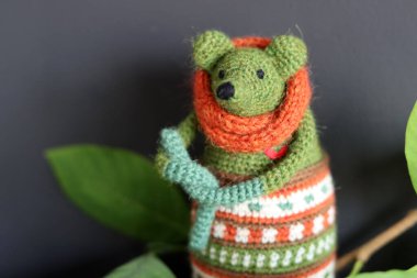 Tığ işi Amigurumi oyuncağı fotokopi alanı olan koyu gri arkaplandaki resmi kapat. Turuncu eşarplı yeşil fare. Güzel el yapımı bir hediye.. 