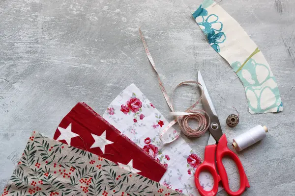 Dikiş araçları: makas, iplik, kumaş, iğne, düğme ve gri arkaplan üzerinde renkli yumuşak pamuk kumaş fotokopi alanı düz bileşimi dikiş aksesuarları 