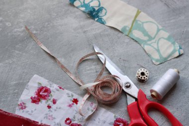 Dikiş araçları: makas, iplik, kumaş, iğne, düğme ve gri arkaplan üzerinde renkli yumuşak pamuk kumaş fotokopi alanı düz bileşimi dikiş aksesuarları 