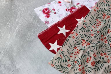 Açık gri desenli arkaplanda farklı pamuk kumaş türleri ve metin için alan. Geri dönüşümlü kumaş giysileri dikiyorum. Çevre dostu moda kavramı. 