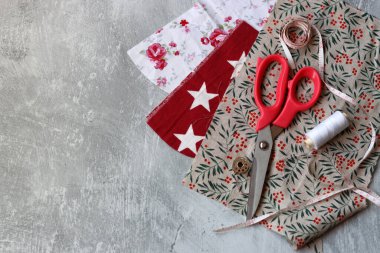 Açık gri desenli arkaplanda farklı pamuk kumaş türleri ve metin için alan. Geri dönüşümlü kumaş giysileri dikiyorum. Çevre dostu moda kavramı. 