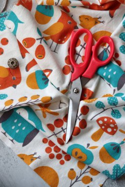 Dikiş araçları: makas, iplik, kumaş, iğne, düğme ve gri arkaplan üzerinde renkli yumuşak pamuk kumaş fotokopi alanı düz bileşimi dikiş aksesuarları 