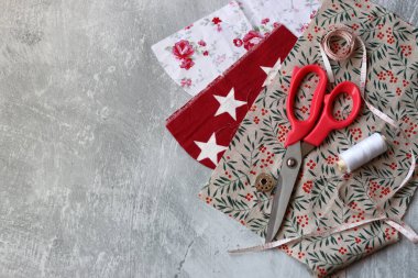 Dikiş araçları: makas, iplik, kumaş, iğne, düğme ve gri arkaplan üzerinde renkli yumuşak pamuk kumaş fotokopi alanı düz bileşimi dikiş aksesuarları 