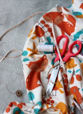 Dikiş araçları: makas, iplik, kumaş, iğne, düğme ve gri arkaplan üzerinde renkli yumuşak pamuk kumaş fotokopi alanı düz bileşimi dikiş aksesuarları 