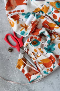 Dikiş projesi devam ediyor. Terzinin masasının fotoğrafını kapat. El yapımı kıyafetler.. 