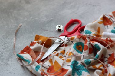 Dikiş araçları: makas, iplik, kumaş, iğne, düğme ve gri arkaplan üzerinde renkli yumuşak pamuk kumaş fotokopi alanı düz bileşimi dikiş aksesuarları 