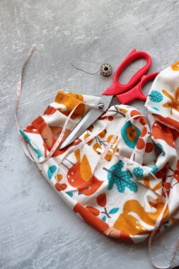 Dikiş araçları: makas, iplik, kumaş, iğne, düğme ve gri arkaplan üzerinde renkli yumuşak pamuk kumaş fotokopi alanı düz bileşimi dikiş aksesuarları 