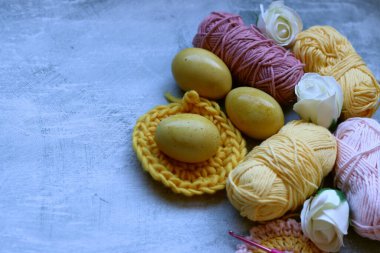 Paskalya geçmişi. Gri arka planda Paskalya yumurtaları, kurdeleler, çiçekler ve tığ işi..