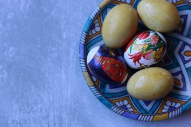 Turkuaz seramik plaka üzerinde paskalya yumurtaları, fotokopi alanı ile desenli arka plan.. 