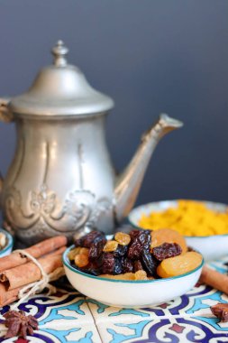 Still life with Traditional oriental spices, nuts, herbs and dried fruit on blue tiled background. Healthy eating concept. 
