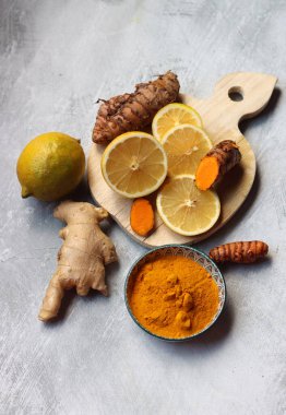 Limon, zerdeçal kökü ve zencefil. Açık gri arkaplan ve fotokopi alanı olan ev yapımı antiviral ilaç malzemeleri. 