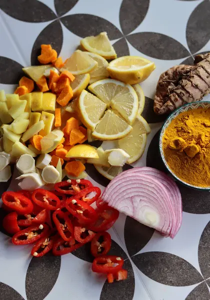 Gri fayanslı arka planda doğranmış elma şarabı. Zerdeçal, zencefil, biber, sarımsak, soğan ve limonun üst görünüm fotoğrafı. 