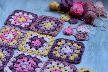 Gri arkaplanda, üzerinde fotokopi alanı olan el yapımı zikzak süsleri. Renkli pamuklu büyükanne meydanı. Tığ işi dokusu fotoğrafı kapat. 