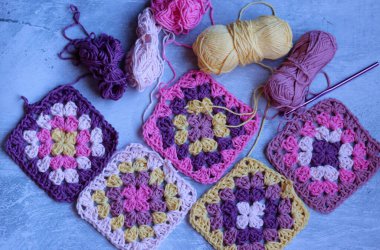 Gri arkaplanda, üzerinde fotokopi alanı olan el yapımı zikzak süsleri. Renkli pamuklu büyükanne meydanı. Tığ işi dokusu fotoğrafı kapat. 