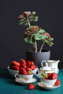 Bir fincan çilekli çay ve koyu arkaplanlı sulu bitki ve metin için yer var. Taze konsept yemek. 
